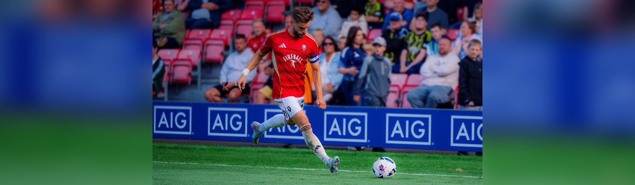 Salford City FC player kicking the soccer ball